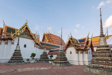 Wat Pho 'daki büyük Buda tapınakları ve çatıları. Karmaşık süslemeler ve parlak altınlar ile süslenmiş, mavi gökyüzüne karşı dizilmiş. Bangkok, Tayland.