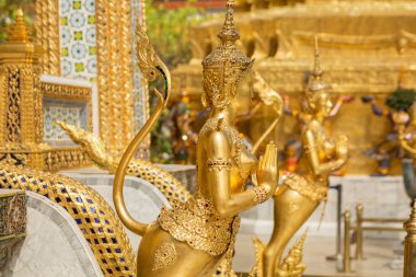 Altın Sawasdee heykelleri, Wat Phra Kaew, Bangkok, Tayland 'da uzun kuyruklu, değerli taşlarla süslenmiş.