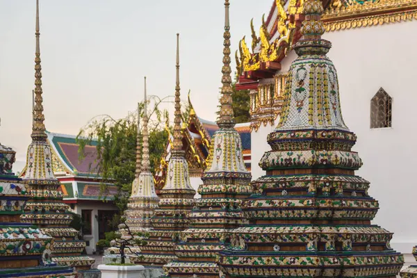 stock image Large pagoda Buddha temples at Wat Pho, beautifully adorned with intricate ornamentation and gleaming gold, set against blue sky. Bangkok, Thailand.