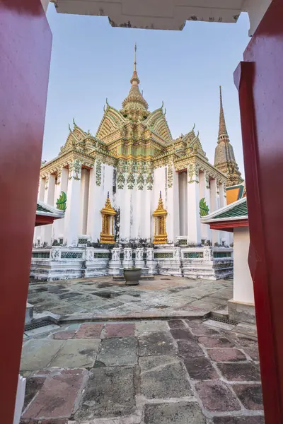 stock image Temple of the Reclining Buddha Wat Pho, richly adorned with gold and mosaic, viewed through the doors, Bangkok, Thailand