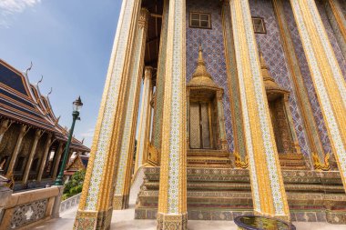 Güneşli bir günde, Bangkok, Tayland 'da, Wat Phra Kaew Tapınağı' nın ana sütunları karmaşık desenler, cam ve taşlarla bezenmiştir.