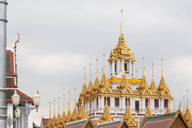 Bangkok, Tayland 'ın göbeğinde yer alan Wat Ratchanatdaram' da çok katmanlı eşsiz bir tapınak olan Loha Prasat 'ın büyüleyici altın kuleleri.