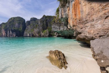 Tayland 'ın Phi Phi Ley Adası' ndaki Maya Körfezi 'nin çarpıcı manzarası, yüksek kireçtaşı kayalıkları, kristal berraklığında turkuaz su ve kumlu bir plaj.