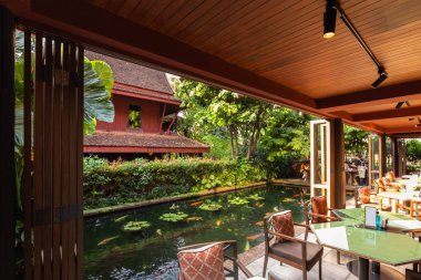 Bangkok, Tayland 'da bir açık hava kafeden Jim Thompsons' ın evinin ve koi havuzunun manzarası