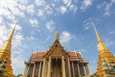 Ornately decorated roofs and towers of Temple of the Emerald Buddha against a blue sky on a sunny day, Bangkok, Thailand