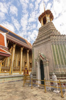 Altın ve süslemelerle zenginleştirilmiş Grand Palace 'daki mozaik çan kulesi güneşli bir günde mavi gökyüzüne karşı, Bangkok, Tayland