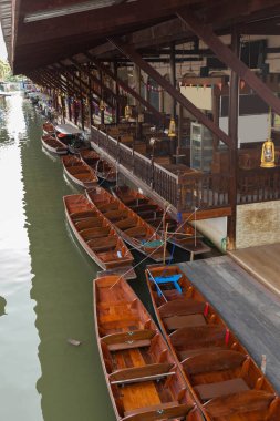 A row of wooden boats docked along the side of a canal, Bangkok. Thailand clipart