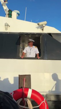 Sırt çantalarını ve bavullarını gören feribotun kaptanı mavi okyanus sularını aşıp Koh Samui, Tayland 'a gitmeye hazır. Chumphon, Tayland - 06 Ağustos 2023.