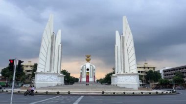 Bangkok 'taki Demokrasi Anıtı kasvetli bir gökyüzüne karşı duruyor, Tayland' ın demokrasiye yolculuğunu sembolize ediyor, şehir trafiğiyle çevrili. Bangkok, Tayland - 25 Kasım 2023.