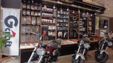 Motosiklet vitrinli, modern koltuklu ve sıcak ışıklandırmalı rahat bir kafe. Özel bir sergi salonu ve günlük yemek alanı karışımı sunuyor. Phuket, Tayland - 05 Kasım 2023.