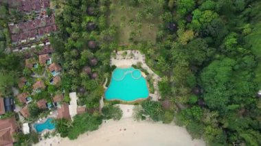 Tayland 'da palmiye ağaçları, yüzme havuzları ve sahil ulaşımlı tropikal bir sahil beldesinin havadan çekilmiş görüntüleri Tayland' ın başkenti Krabi 'de sakin ve lüks bir tatil beldesini gösteriyor..