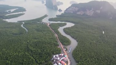 Sakin sularla çevrili yemyeşil adalar ve uzak yüksek kaya oluşumları Samet Nangshe bakış açısıyla sakin ve resimli bir manzara yaratır..