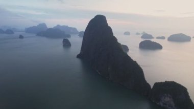 Sakin sularla çevrili yemyeşil adalar ve uzak yüksek kaya oluşumları Samet Nangshe bakış açısıyla sakin ve resimli bir manzara yaratır..