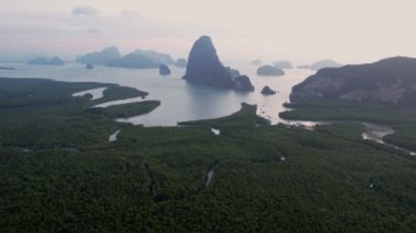 Sakin sularla çevrili yemyeşil adalar ve uzak yüksek kaya oluşumları Samet Nangshe bakış açısıyla sakin ve resimli bir manzara yaratır..
