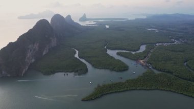 Sakin sularla çevrili yemyeşil adalar ve uzak yüksek kaya oluşumları Samet Nangshe bakış açısıyla sakin ve resimli bir manzara yaratır..