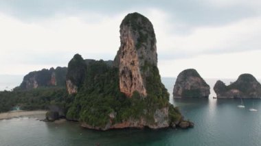 Tayland 'ın Krabi kentindeki ünlü Railay Sahili' ni çevreleyen çarpıcı kireçtaşı kayalıkların havadan görünüşü, kıyı boyunca uzun kuyruklu tekneler ve manzaralı plajın keyfini çıkaran turistler.. 