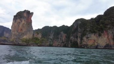 Tahta bir tekneye binip Krabi kıyısına git, yemyeşil yeşil kayalıklarla kaplı yüksek kireçtaşı kayalıkların yanından geç, önünde deniz uzanıyor..