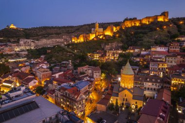 Tiflis 'in gece aydınlanması Narikala kalesi ve Gürcistan' ın eski Tiflis kasabasının insansız hava aracı gözünden. Gün batımında Tiflis 'in güzel panoramik manzarası.