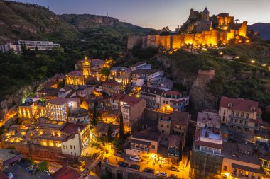 Tiflis 'in gece aydınlanması Narikala kalesi ve Gürcistan' ın eski Tiflis kasabasının insansız hava aracı gözünden. Gün batımında Tiflis 'in güzel panoramik manzarası.