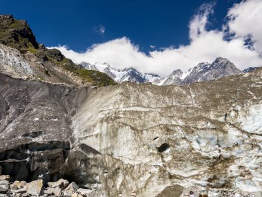 Görülebilir buz oluşumlarına sahip Chalaadi buzulu, Gürcistan 'ın Svaneti kentinde kayalık bir arazi ve dağlık zemin ile çevrili bir su akıntısını serbest bırakır. Büyük bir kaya, akan suyun içinde duruyor..