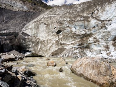 Görülebilir buz oluşumlarına sahip Chalaadi buzulu, Gürcistan 'ın Svaneti kentinde kayalık bir arazi ve dağlık zemin ile çevrili bir su akıntısını serbest bırakır. Büyük bir kaya, akan suyun içinde duruyor..