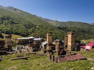 Traditional Svaneti towers standing tall amidst a village nestled in a lush green valley. Surrounded by mountains, these historic structures are a testament to the regions architectural heritage. clipart