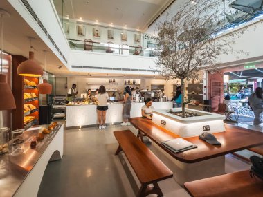 Minimalist tasarımı olan çağdaş fırın ve kafe, ahşap masalar, taze pastalar ve müşteriler için davetkar bir atmosfer içeriyor. Limasol, Kıbrıs - 27 Ekim 2024.
