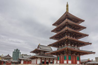 Japonya 'nın Nara kentindeki Kofuku-ji Tapınağı' nın görkemli beş katlı tapınağı bulutlu bir gökyüzüne karşı dimdik ayakta duruyor. Karmaşık detaylarla antik ahşap mimari. Japon mirasının büyüleyici bir sahnesi..