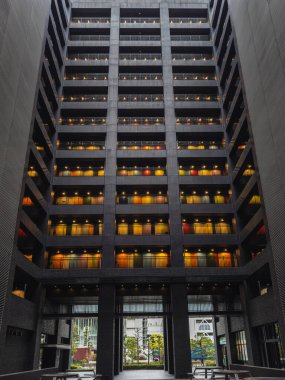 Japonya 'da geceleri renkli balkonları olan modern bir apartman. Geometrik mimari, aydınlatılmış odalar ve sakin bir avlu çarpıcı bir görüntü yaratır. Kentsel, mimari veya