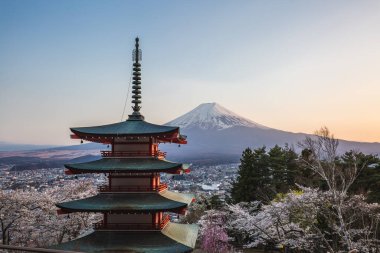 Japonya 'daki Chureito Pagoda' dan Fuji Dağı 'nın göz kamaştırıcı gündoğumu manzarası, kiraz çiçekleri tam çiçeklerle birlikte. Nefes kesici manzara ikonik simgeler ve canlı bahar renkleri sergiliyor..