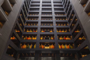 Aydınlatılmış balkonları olan modern bir apartman. Her kattaki renkli aksanlar canlı bir atmosfer yaratıyor. Geometrik çizgiler ve mimari ayrıntılar göze çarpar. Çarpıcı bir örnek.