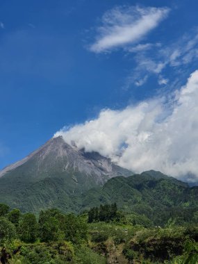 Merapi Dağı 'nın gündüz dumanı püskürten fotoğrafı. Bu dağ Yogyakarta şehrinin kuzey tarafında yer almaktadır.