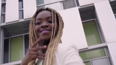 Uzun saçlı, güzel, gülümseyen Afrikalı kız dans salonu twerk 'i, açık havada modern sokak dansı. Seks Dansı. 4 bin. Yüksek kalite 4k görüntü