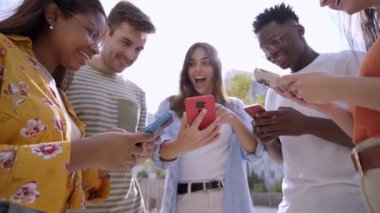 Cep telefonlarıyla cep telefonlarını açıp ekranda komik bir şeyler izleyen bir grup genç. Akıllı telefona benzeyen şaşırmış yüzler. Teknoloji bağlantı topluluğu ve sosyal medya kavramı 
