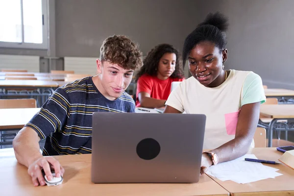 Νέοι Πολυφυλετικοί Φοιτητές Που Χρησιμοποιούν Φορητό Υπολογιστή Ενώ Κάθονται Στο — Φωτογραφία Αρχείου