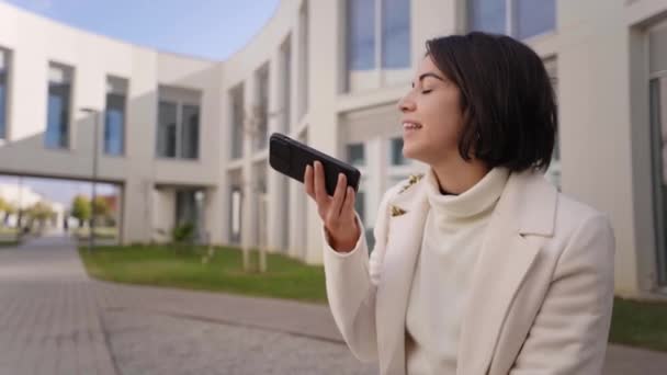 Junge Geschäftsfrau Aus Latina Sendet Eine Sprachnotiz Vor Einem Bürogebäude — Stockvideo