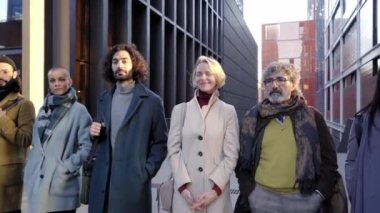 Mutlu çeşitli iş adamları ofiste bir arada duruyor, grup portresi. Çok ırklı, uluslararası, genç, profesyonel çalışan şirket yöneticisinin gülümsemesi kameraya bakıyor. Kalite 4k