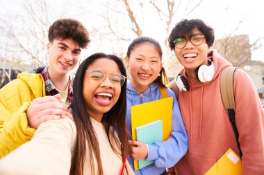 Gülümseyen dört uluslararası öğrencinin selfie 'si fotoğraf çekimi için poz veriyor, Latin çekici bayan okul kütüphanesi ve klasöründe. Toparlanmış, neşeli, zeki ve başarılı gençlik