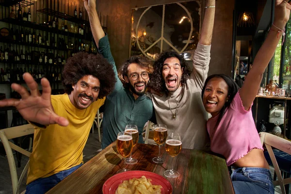 Dört neşeli genç arkadaştan oluşan bir grup indirimli saatlerde barın içinde selfie portresi çekiyorlar. Mutlu insanlar kameraya bakıp gülümserken eğleniyorlar. Toplum kavramı, gençlik yaşam tarzı ve arkadaşlık.