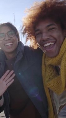 Dikey şarjör. Neşeli bir grup arkadaş kış kıyafetleri giyerek selfie çekiyorlar. Sosyal medya iletişimi