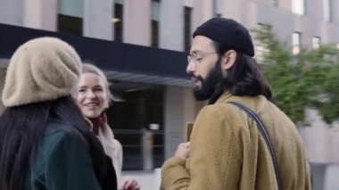 Four multiethnic business people talk standing on the street in a financial district outside a city office area. High quality 4k footage
