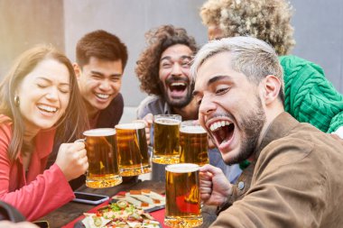 Happy friends taking a selfie at the terrace restaurant drinking beers. High quality photo