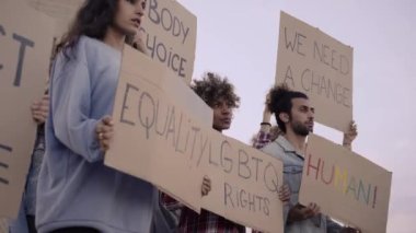 Göstericiler pankart tutan bir grup protestocu. Gay gururlu LGBT topluluğu. Gökkuşağı bayrağı.