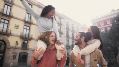 Slow motion of a Two beautiful European couples in piggyback laughing and having fun. Friendship concept . High quality photo