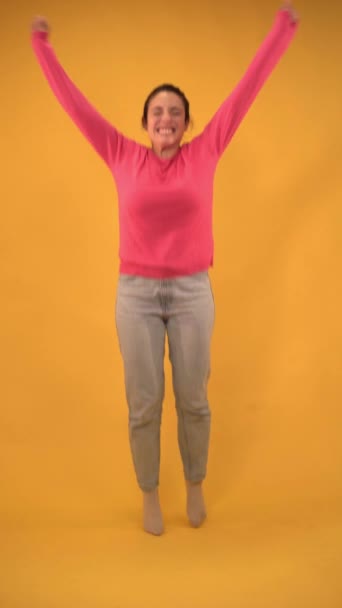 Dikey Stüdyoda Sarı Arka Planda Zıplayan Gülümseyen Bir Model Güzel — Stok video