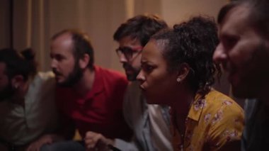 Fans of a soccer team follow the game at home, celebrating the winning goal in the World Cup match. Enthusiastic people enjoying the sporting success watching on TV.