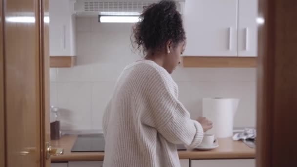 Молодая Улыбающаяся Женщина Афроамериканская Домохозяйка Пьет Кофе Чай Пользуется Мобильным — стоковое видео