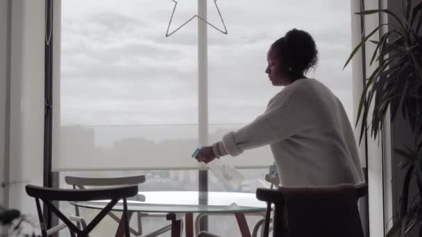 Een Jonge Afro Amerikaanse Vrouw Spuit Reiniger Een Glazen Tafel — Stockvideo