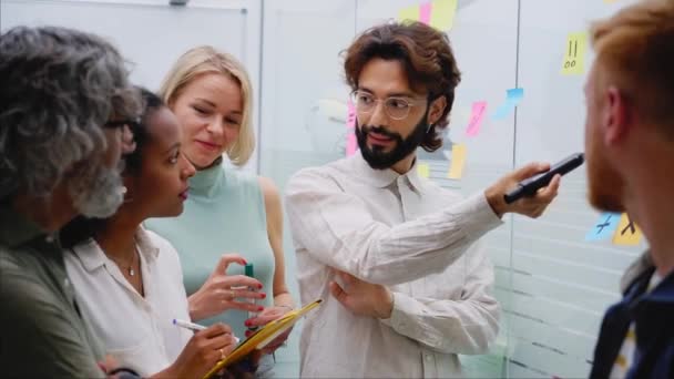 办公室里创造性同事的会面 来自企业家团队的几位员工为公司的未来起立 交换意见 讨论和撰写新思路 商界人士 — 图库视频影像