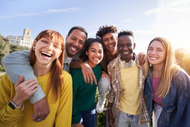 Travel with happy friends. Young smiling people looking at camera hugging. Group of multicultural boys and girls having fun outdoors celebrating vacations Erasmus together in Europe. Modern lifestyle. clipart